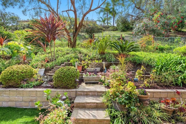 view of yard featuring fence and a vegetable garden