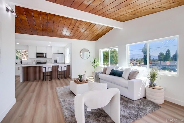 living room with lofted ceiling with beams, light wood-style floors, wood ceiling, and baseboards