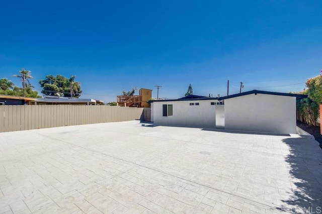 rear view of property with fence and stucco siding