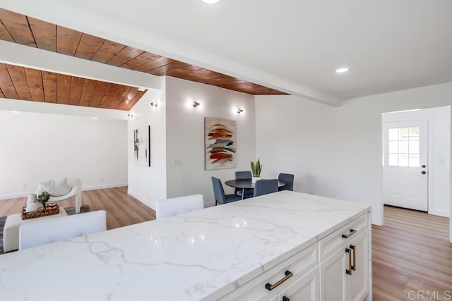 kitchen with light stone counters, wooden ceiling, white cabinetry, and light wood finished floors