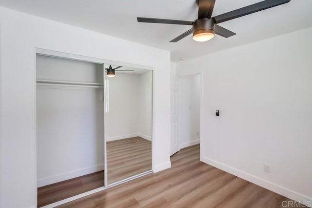 unfurnished bedroom with ceiling fan, light wood finished floors, a closet, and baseboards