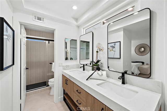 bathroom with visible vents, a sink, toilet, and double vanity