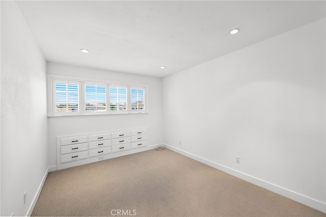 empty room featuring light carpet, baseboards, and recessed lighting