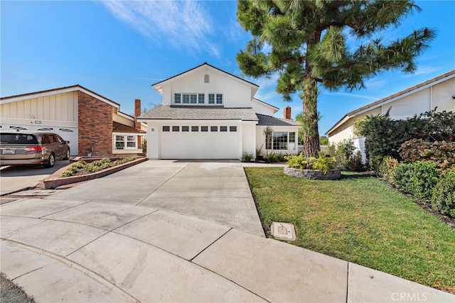 traditional-style house featuring a garage, driveway, a front lawn, and stucco siding