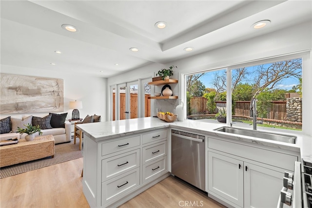 kitchen featuring a sink, light wood finished floors, light stone counters, and dishwasher