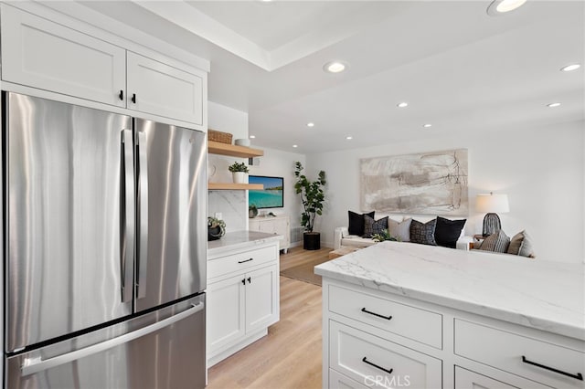 kitchen with open shelves, recessed lighting, light wood-style floors, white cabinets, and stainless steel fridge