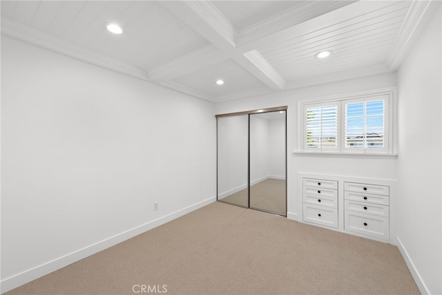 unfurnished bedroom with light carpet, coffered ceiling, baseboards, ornamental molding, and beam ceiling