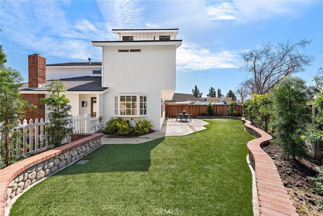 back of property with a patio, a lawn, a fenced backyard, and stucco siding