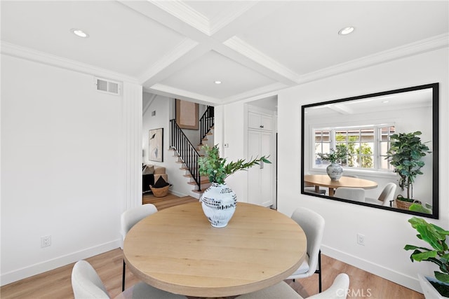 dining space with beam ceiling, visible vents, light wood-style flooring, ornamental molding, and stairs