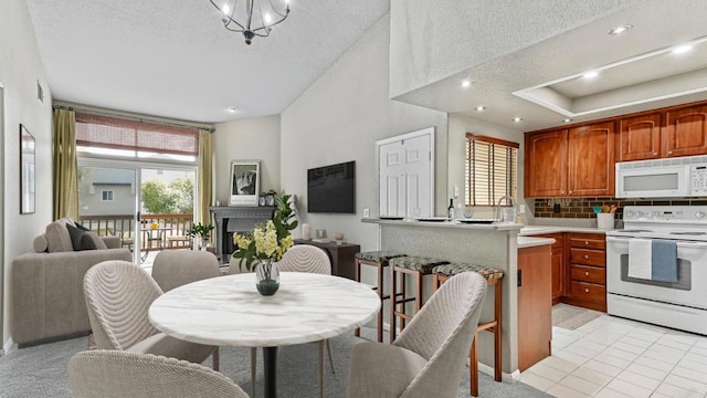 dining area featuring a brick fireplace, a textured ceiling, and a wealth of natural light