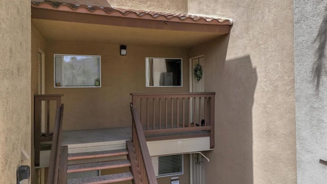 doorway to property featuring a tile roof and stucco siding