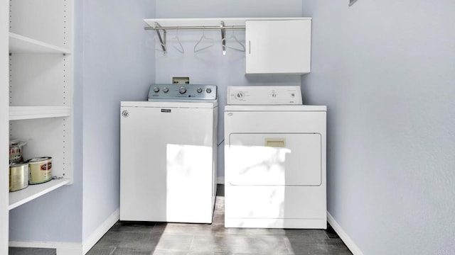 laundry area with laundry area, washing machine and dryer, baseboards, and wood finished floors