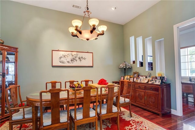 dining area with visible vents, a notable chandelier, and wood finished floors