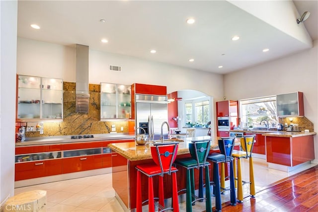 kitchen featuring arched walkways, stainless steel built in fridge, visible vents, and modern cabinets