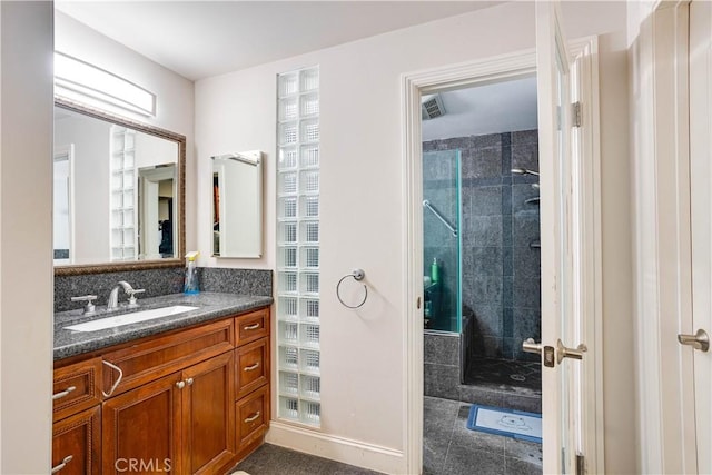 full bath with visible vents, tiled shower, and vanity