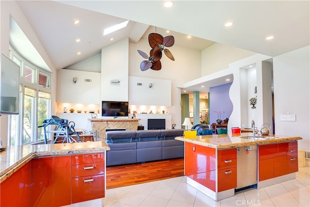 kitchen featuring light tile patterned floors, high vaulted ceiling, a sink, visible vents, and dishwasher