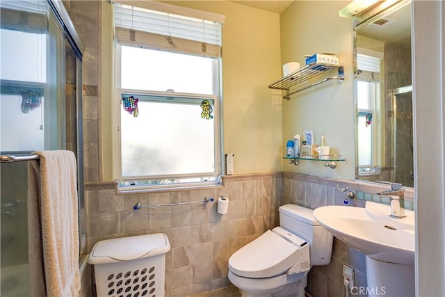 bathroom featuring a stall shower, a wealth of natural light, tile walls, and toilet