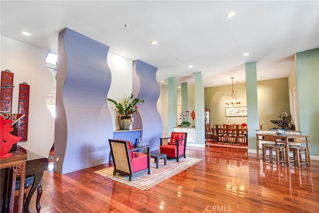 sitting room with a notable chandelier, baseboards, hardwood / wood-style flooring, and recessed lighting