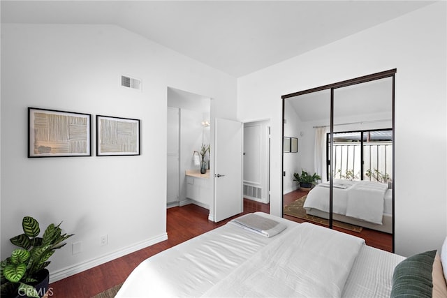 bedroom with visible vents, vaulted ceiling, baseboards, and wood finished floors