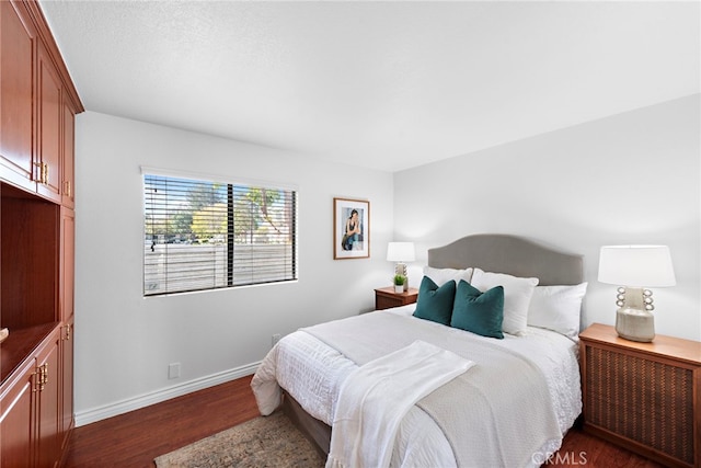 bedroom featuring radiator heating unit, baseboards, and dark wood-style flooring