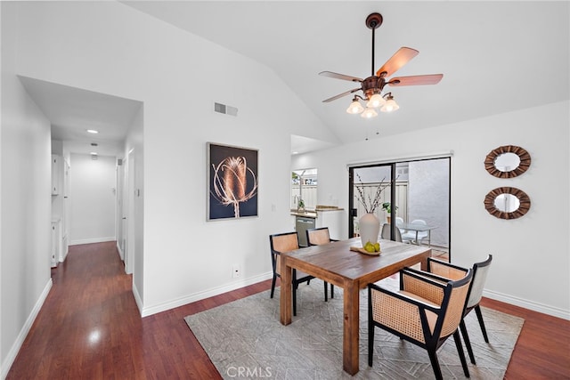 dining space with high vaulted ceiling, wood finished floors, a ceiling fan, visible vents, and baseboards