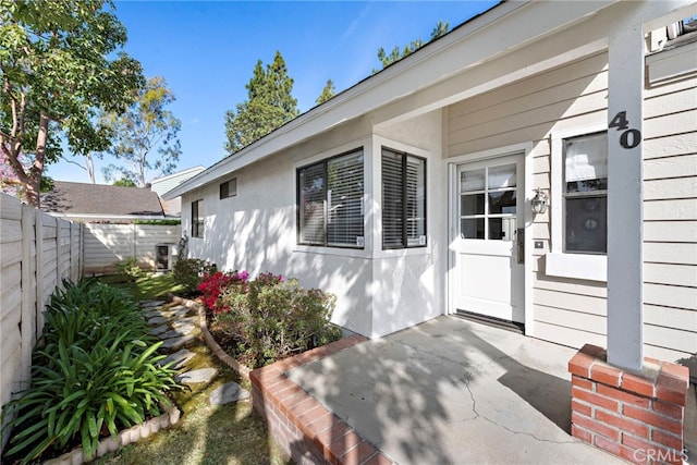 property entrance with a patio area and fence