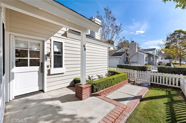 exterior space with a residential view, fence, and a chimney