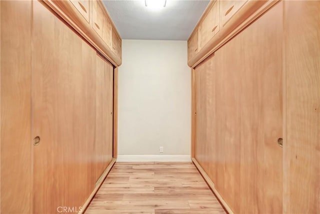 spacious closet featuring light wood-style flooring