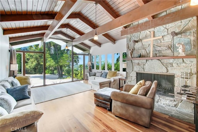 living room with vaulted ceiling with beams, wooden ceiling, a fireplace, and wood finished floors