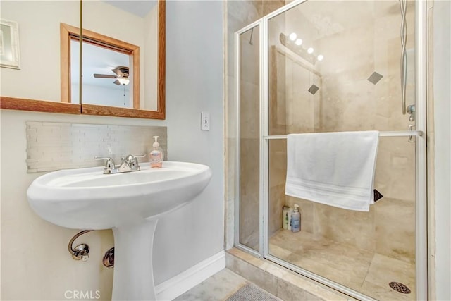 bathroom featuring a ceiling fan, a shower stall, and decorative backsplash