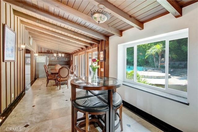 sunroom / solarium featuring vaulted ceiling with beams, wooden ceiling, and an inviting chandelier