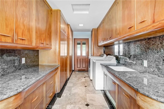 laundry room featuring washer and dryer, cabinet space, and a sink