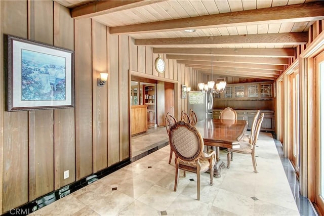 dining room with vaulted ceiling with beams, wood ceiling, wooden walls, and a chandelier