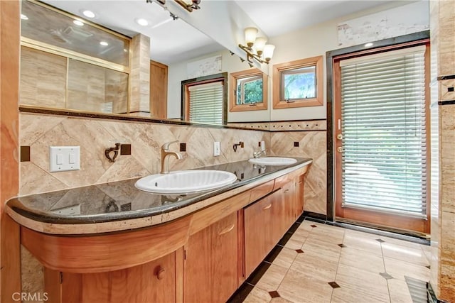 full bath with a tile shower, double vanity, tile patterned flooring, and a sink