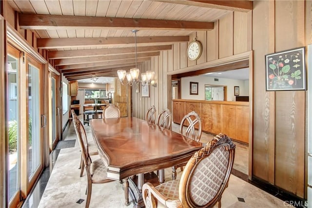 dining space featuring wood walls, beamed ceiling, wooden ceiling, and an inviting chandelier