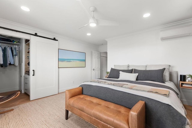 bedroom with ornamental molding, an AC wall unit, a barn door, and recessed lighting