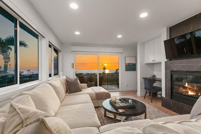 living room with a fireplace, baseboards, and recessed lighting