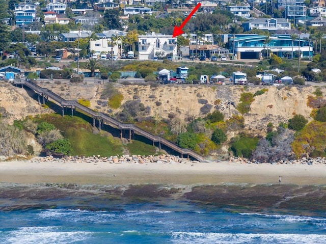 birds eye view of property with a water view and a view of the beach