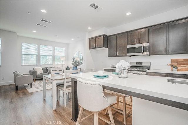 kitchen with appliances with stainless steel finishes, recessed lighting, visible vents, and light wood-style floors