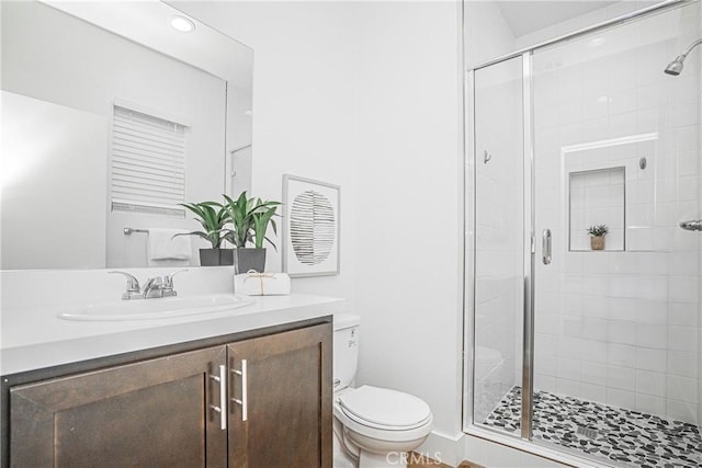 full bath featuring a stall shower, vanity, and toilet