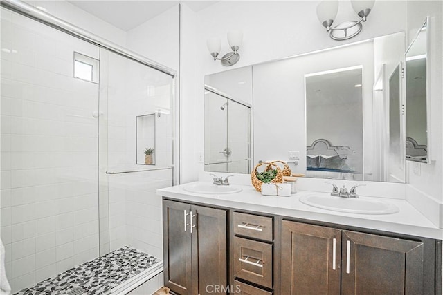 full bathroom featuring double vanity, a shower stall, and a sink