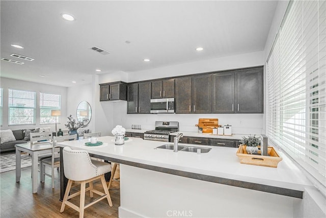 kitchen featuring visible vents, dark wood-style floors, stainless steel appliances, a sink, and recessed lighting