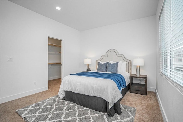 carpeted bedroom featuring a spacious closet, baseboards, and recessed lighting