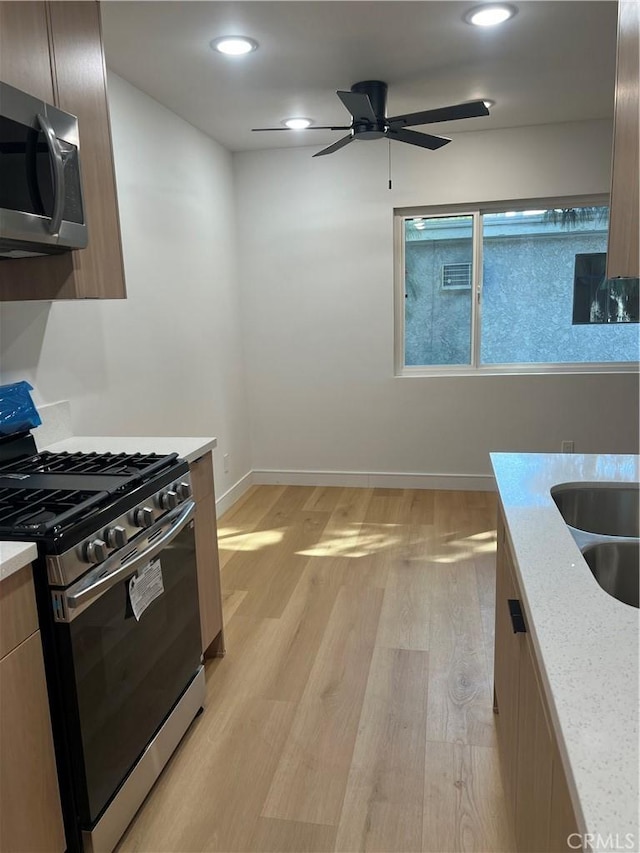 kitchen featuring light wood finished floors, recessed lighting, appliances with stainless steel finishes, ceiling fan, and baseboards