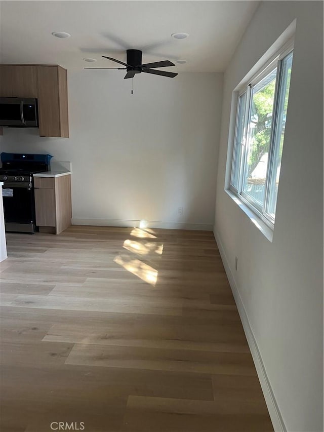 interior space featuring a ceiling fan, recessed lighting, light wood-style flooring, and baseboards