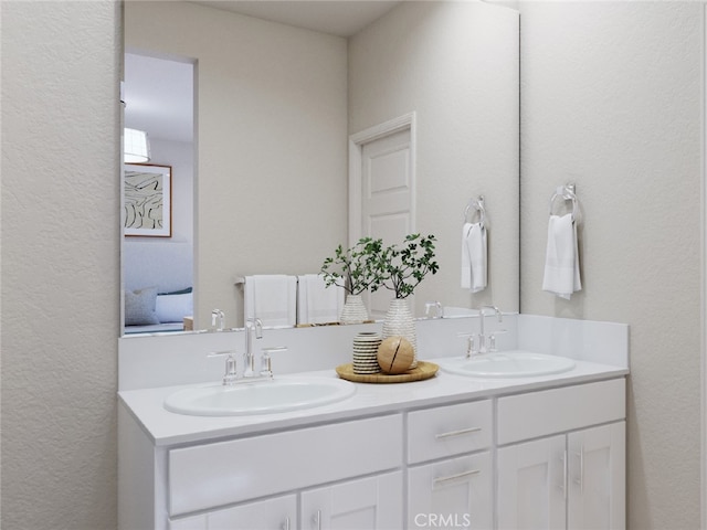 bathroom with a textured wall, double vanity, and a sink