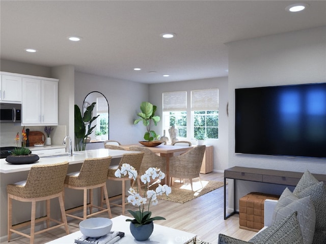 living area with recessed lighting and light wood finished floors