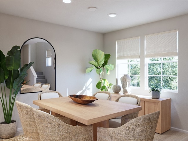 dining space with light wood finished floors, stairway, and recessed lighting