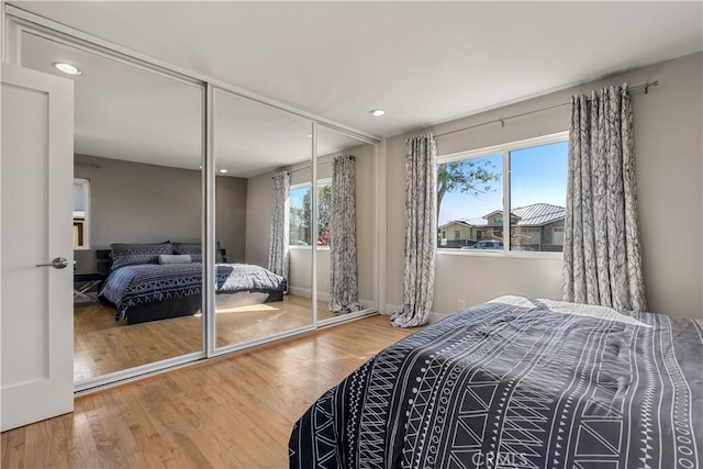 bedroom featuring recessed lighting, wood finished floors, a closet, and baseboards