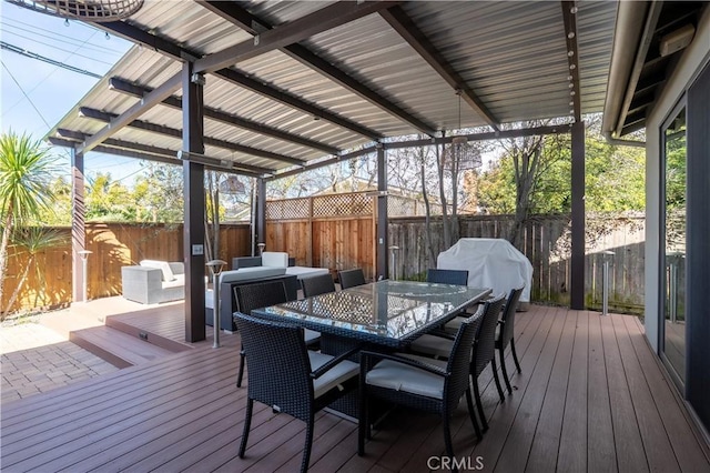 deck featuring grilling area, outdoor dining area, and a fenced backyard